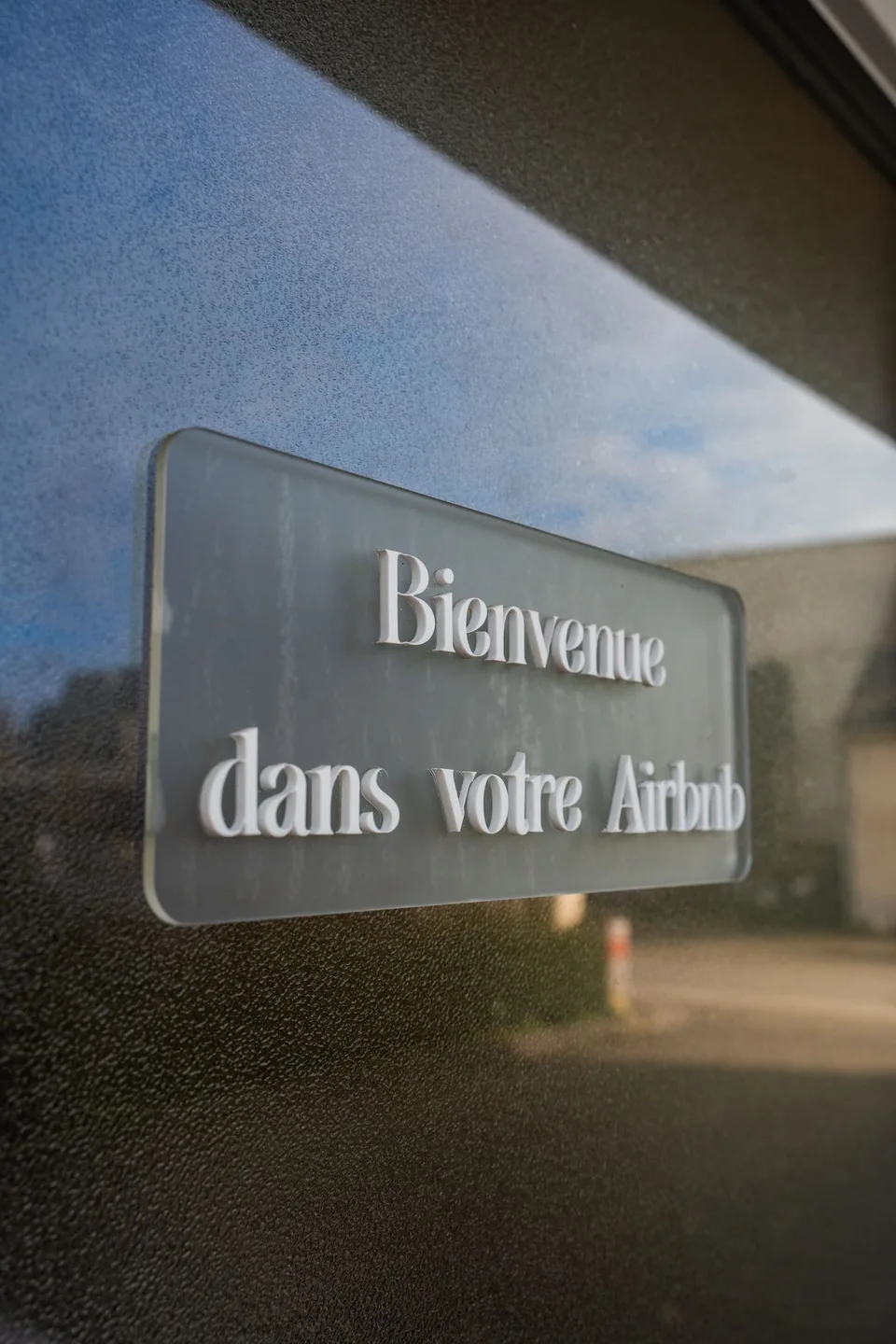 La plaque de bienvenue sur la porte vitrée de l'entrée indépendante